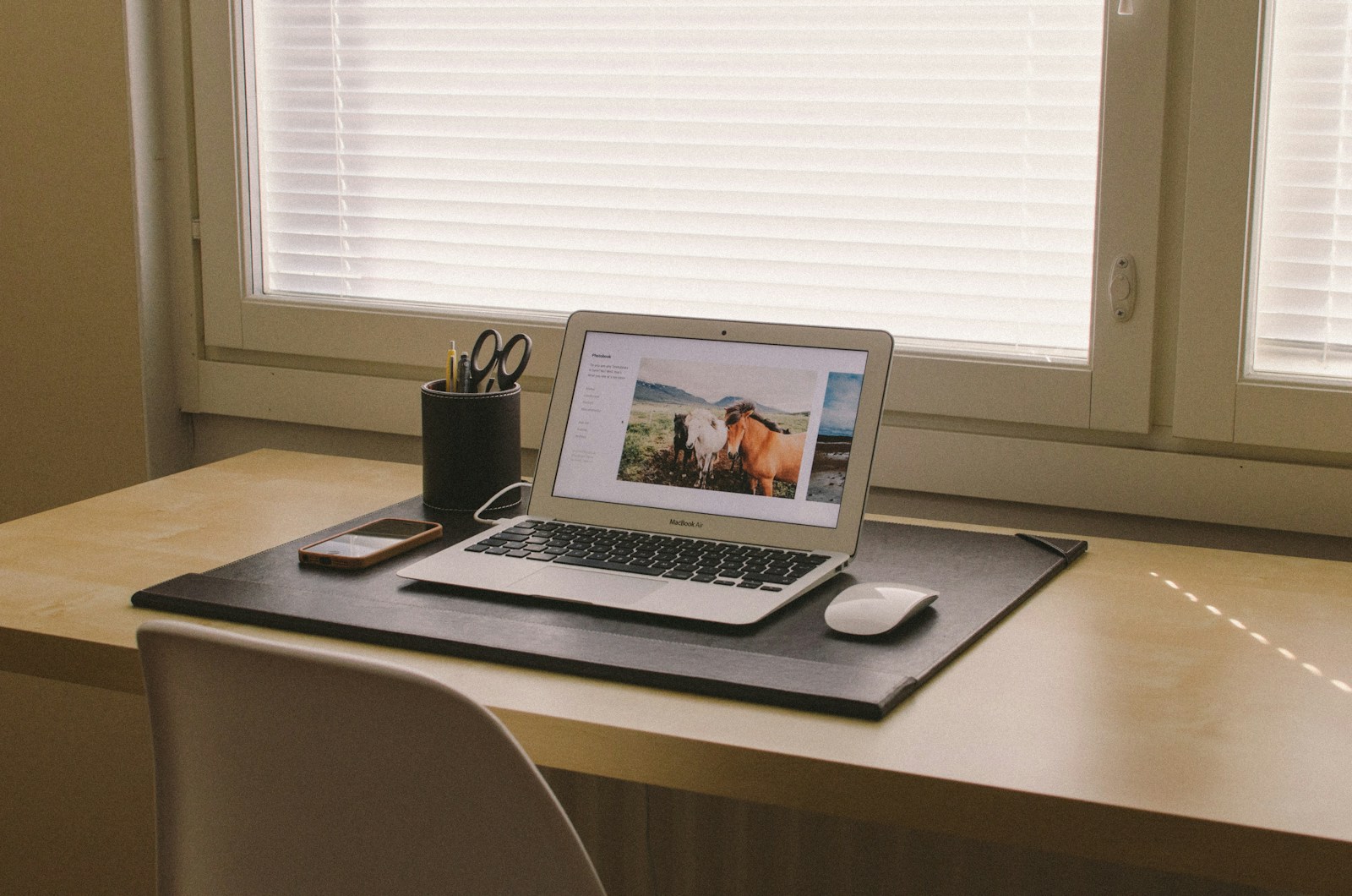 Un poste de travail simple, avec un ordinateur portable posé sur un bureau en bois